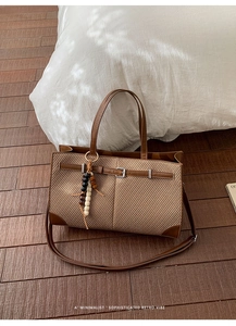 Detail der Retro-Tragetasche mit braunem Leder, beige Geflecht und Holzperlen-Anhänger