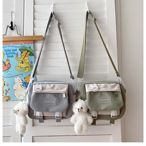 Detail of canvas shoulder bags with fashion tags and cute plush bear accessories