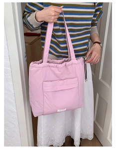 Detail showing pink drawstring tote bag with large front pocket and white logo label