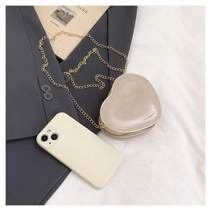 Mini-Herz-Kettentasche in Creme-Beige im Vergleich zum Telefon für kompakte Größe