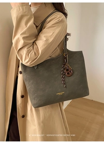 Détail du sac cabas en suédine montrant la bandoulière en cuir et la boucle métallique