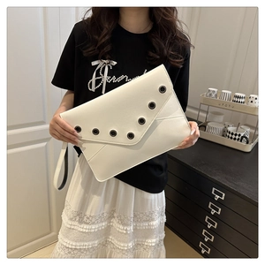 Détail de la pochette enveloppe blanche avec œillets métalliques noirs et dragonne pratique