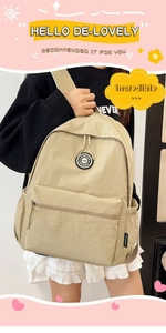Close-up of khaki nylon backpack with circular brand logo and front zipper pocket detail