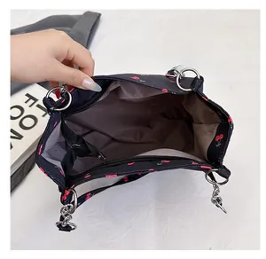 Detail view of the cherry print tote bag with metal chain and grey fabric lining