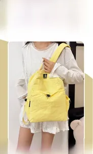 Detail view of the bright yellow travel backpack featuring waterproof crinkle nylon fabric