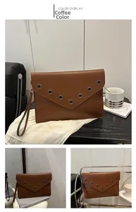 Détail d'une pochette enveloppe marron café avec rivets, rabat en V et dragonne