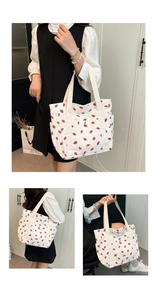 Dettaglio della borsa tote in velluto a coste bianco con motivi a fragola e tasche