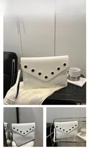 Vue détaillée d'une pochette enveloppe blanche en similicuir avec œillets métalliques