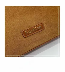 Macro detail of brown leather texture with stitched oval logo patch and golden text