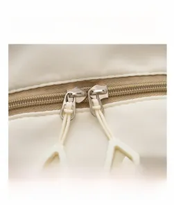 Macro shot of smooth dual zippers with white triangle pull tabs on kids backpack