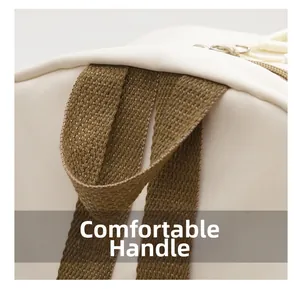 Macro detail of the white backpack's durable woven brown handle and metal zippers