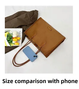 Detailed macro view of large brown suede tote bag compared with a smartphone