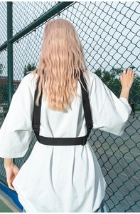 Vue détaillée de la boucle de gilet tactique noire réglable sur une sangle en nylon sur un t-shirt