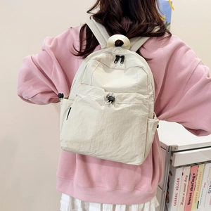 Fashionable beige outdoor travel backpack with drawstring pocket shown on a model