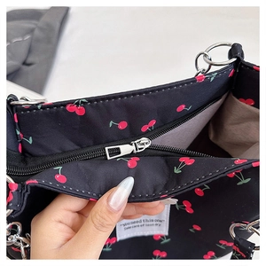 Detailed close-up of cherry print tote bag featuring smooth metal zipper and brown lining