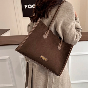 Detail of vintage coffee brown suede tote bag with gold logo and long shoulder straps