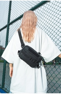 Gros plan sur le sac tactique noir avec système MOLLE et bande velcro pour hommes