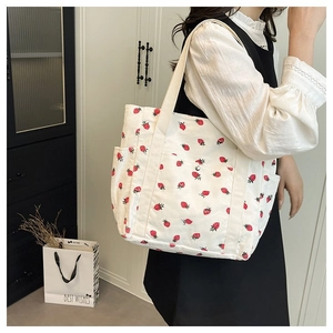 Dettaglio della borsa tote in velluto a coste bianco con stampe di fragole rosse