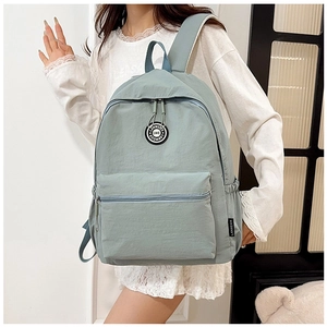 Detail of light blue waterproof nylon backpack with minimalist logo and smooth texture