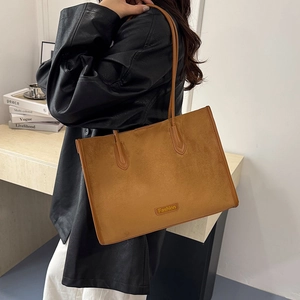 Detail view of the deep camel tote bag showing premium suede texture and handle stitching