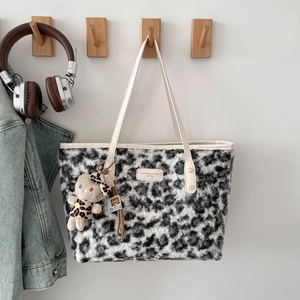 Winter leopard print faux fur tote bag with leather strap and plush charm on wooden hook