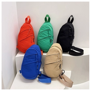 Plusieurs sacs de poitrine en nylon imperméable coloré sur des plateformes blanches