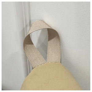 Gros plan détaillé de la sangle tissée et de la texture du tissu du sac de poitrine kaki