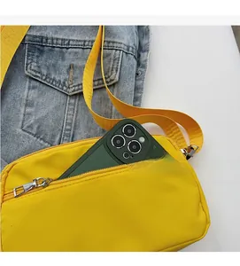 Dettaglio borsa a tracolla in nylon giallo acceso con grande capacità e tasca cellulare