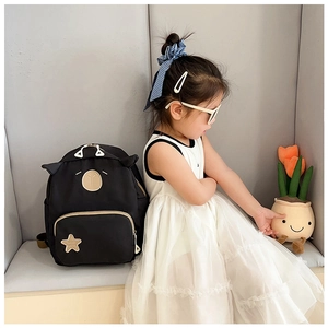 Detail of cute cat ears and bear embroidery on this black canvas children backpack