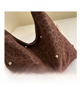 Detail showing brown leopard print hobo bag texture with gold metal rivet ornaments