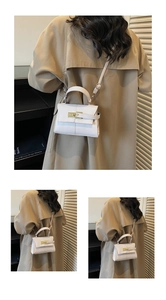 Detailed macro view of the white faux leather texture and gold twist lock on the mini bag