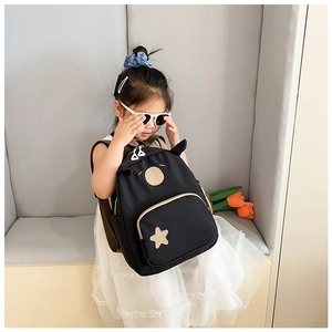 Close-up of cute black kids backpack with star detail and ear design on a girl