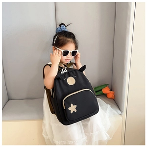 Close-up of black kids backpack featuring cute animal ears and a star-shaped pocket detail