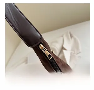 Detail showing smooth gold metal zipper and leather strap on leopard print bag
