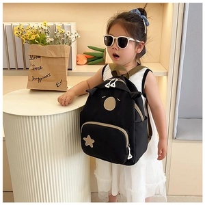 Detailed view of kids cartoon bear backpack with star patch on a cute girl model