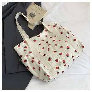 Dettaglio della borsa tote in velluto a coste bianco con stampa fragola e fibbia in metallo