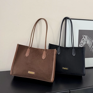 Close-up of brown and black suede tote bags with Fashion logo on a modern display