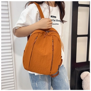 Detail view of large capacity orange casual backpack with multi-pocket storage and straps