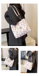 Detail view of cherry print tote bag with stylish chain strap and canvas texture