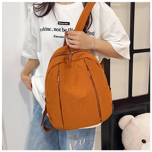 Detail view of caramel orange canvas backpack with dual vertical zipper pockets