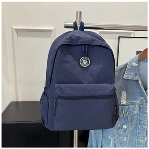 Deep blue nylon backpack detail showing durable water-resistant fabric and multi-pocket design
