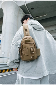 Tactical khaki crossbody bag worn by model showing size and practical D-ring details