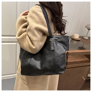 Detailansicht der schwarzen Shopper-Tasche mit Litschi-Struktur und silbernen Sternnieten