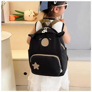 Detail of cute black cartoon kids backpack featuring animal ears and star embroidery