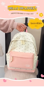 Detailed view of cream and pink polka dot backpack with front zip pocket and logo