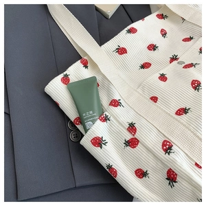 Dettaglio della borsa tote in velluto bianco con motivi di fragole e spalline larghe
