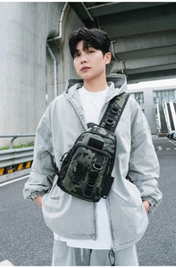 Tactical army green camo sling bag shown on male model in urban outdoor setting