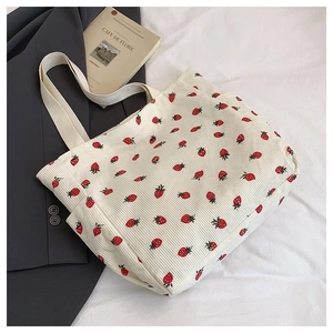 Dettaglio della trama della borsa tote in velluto a coste bianco con stampa fragola