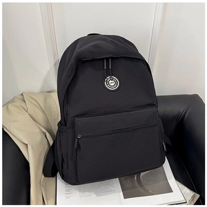 Detail of black nylon backpack with brand logo and water-resistant fabric texture