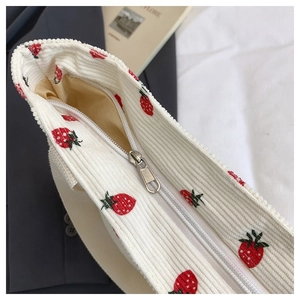 Dettaglio ricamo fragola su borsa tote in velluto a coste con zip argentata